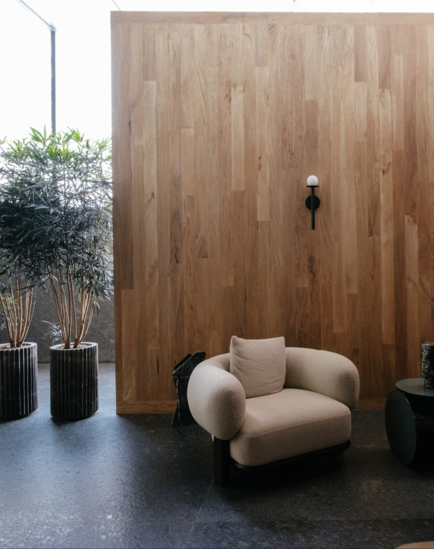two plush chairs in front of a wooden wall