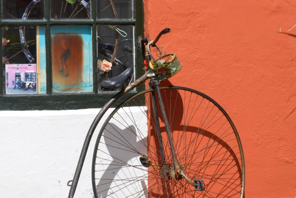 old-fashioned bicycle leaning against an orange wall