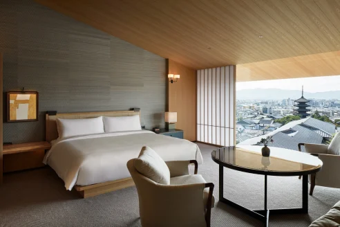 Sleek hotel room with wooden accents, overlooking urban Tokyo