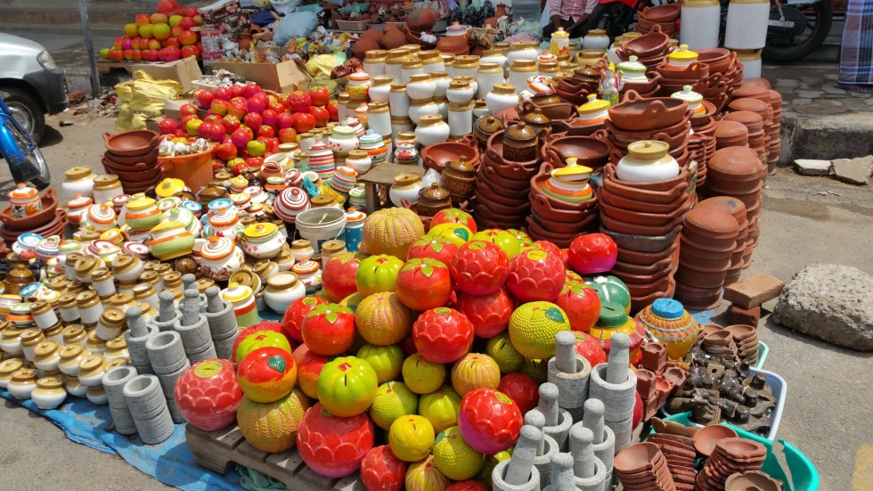 a colorful table of pots at a street market