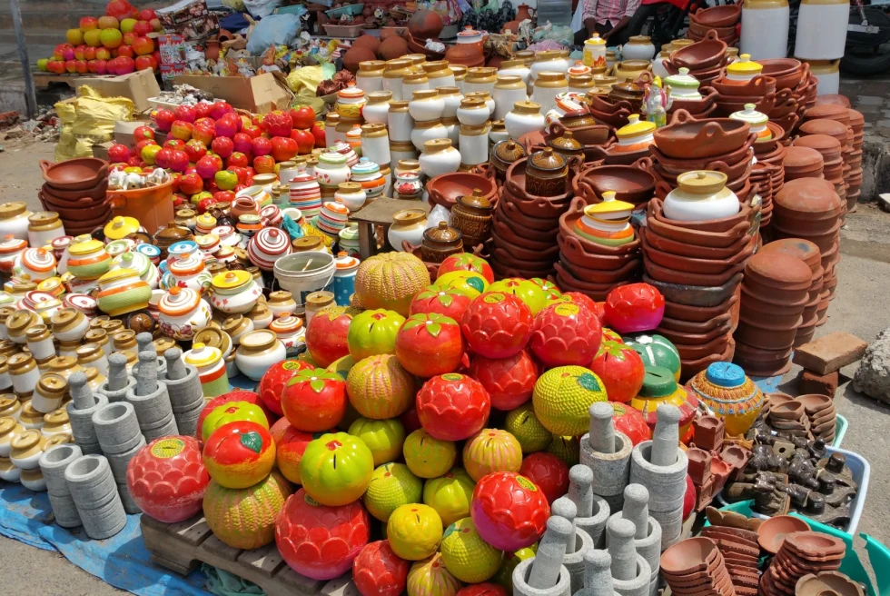 a colorful table of pots at a street market