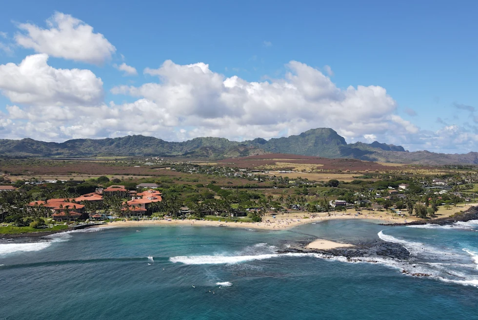 body of water next to beach with mountains in the background