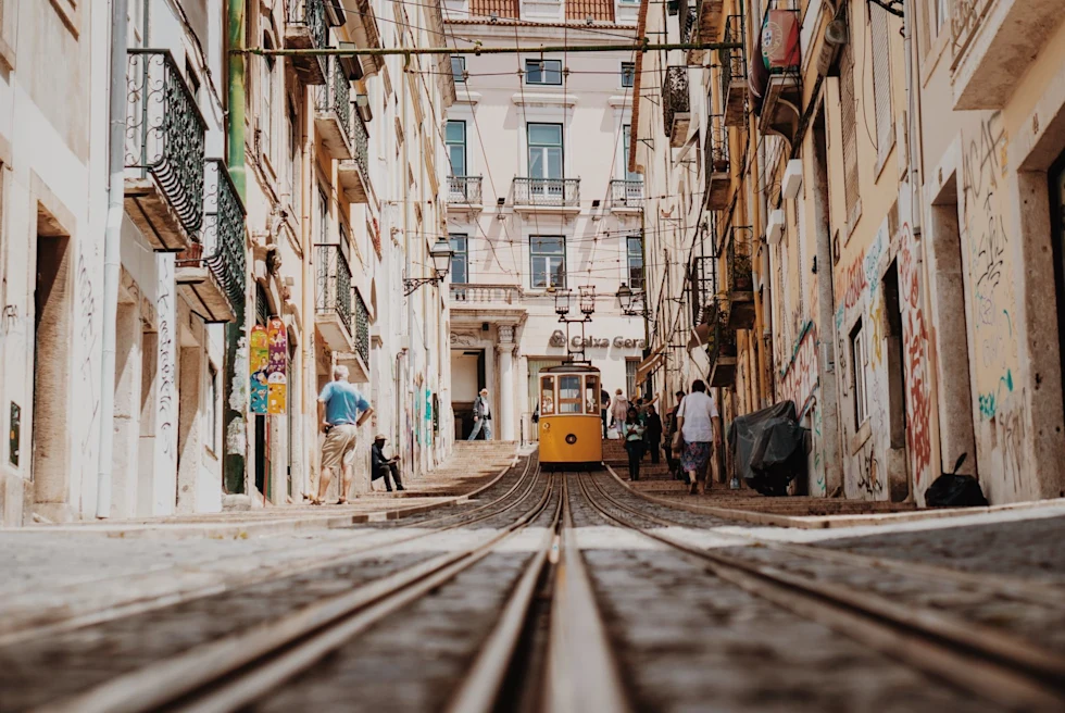 yellow cable car in a narrow city street