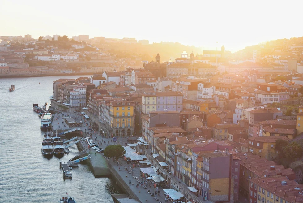 a street running riverside of an old dense city at sunset
