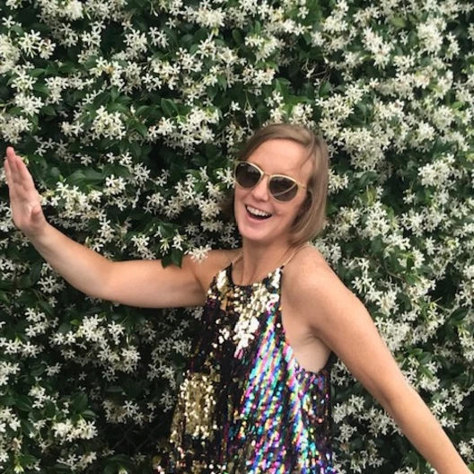Travel advisor posing in front of a flower tree