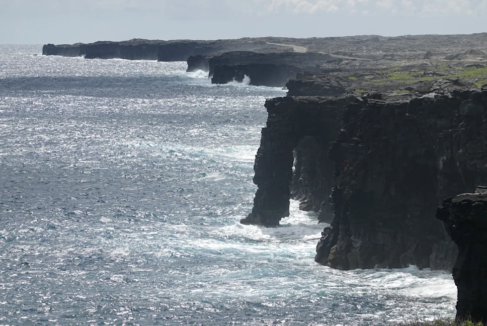 rocky cliff next to body of water during daytime