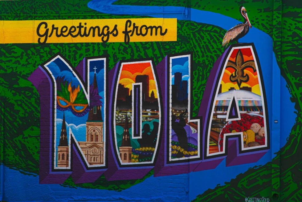 colorful wall mural that read "Greetings from Nola"