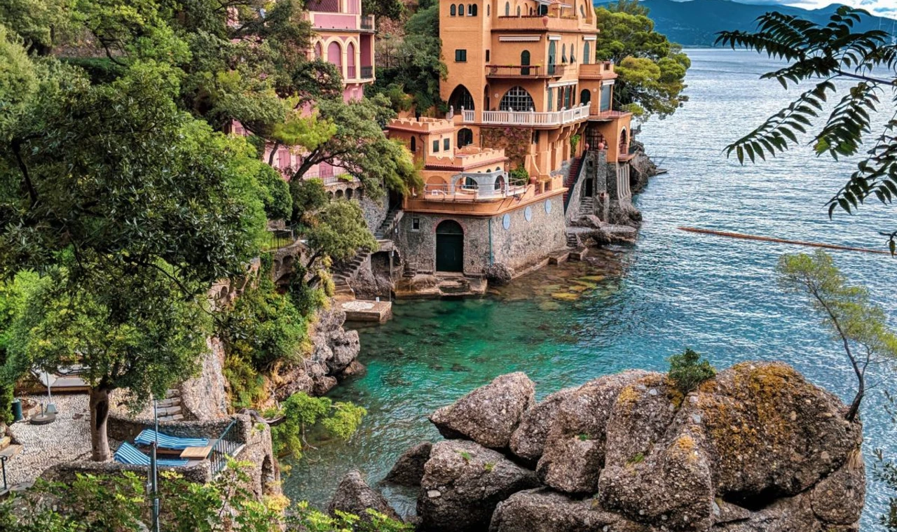 Yellow building on a cliffside near a body of water. 
