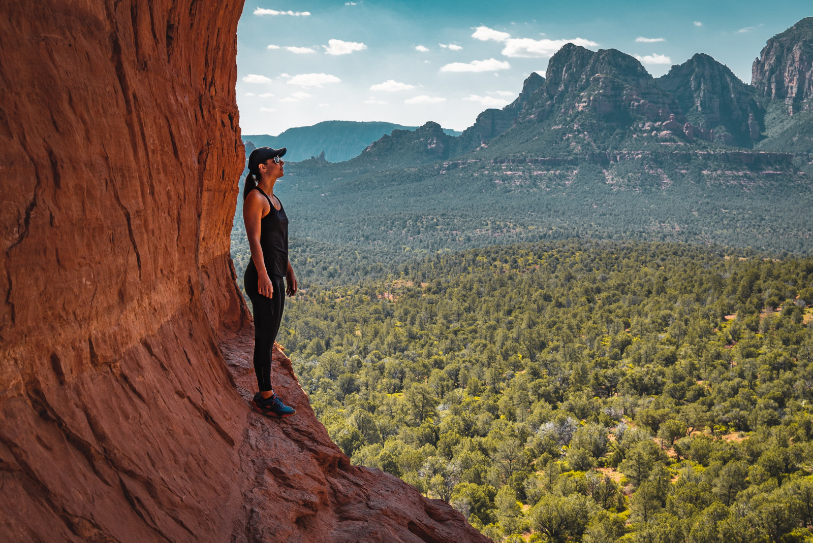A woman standing on a red rock formation in Sedona, Arizona. 