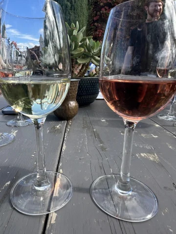 A picture of two wine glasses placed on a table during daytime.