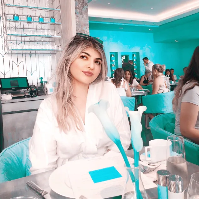 Travel Advisor Lora Gavgavyan is in a restaurant with blue background.