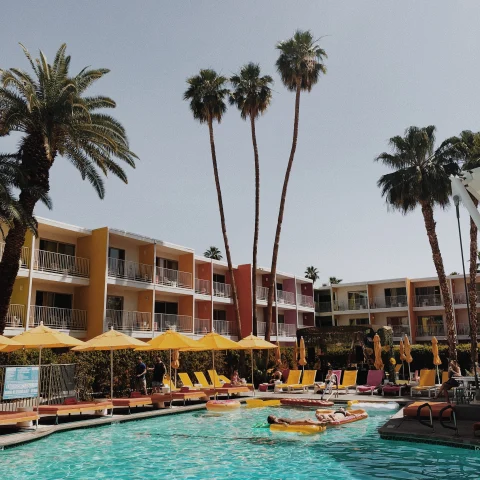 A hotel pool surrounded by yellow umbrellas in Palm Springs. 