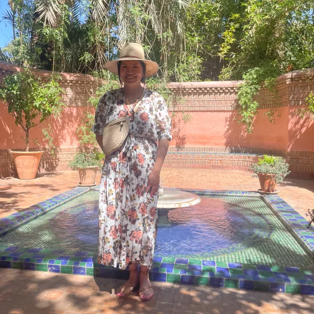 Travel Advisor Tarika Richter in a hat, a flowery dress outside.