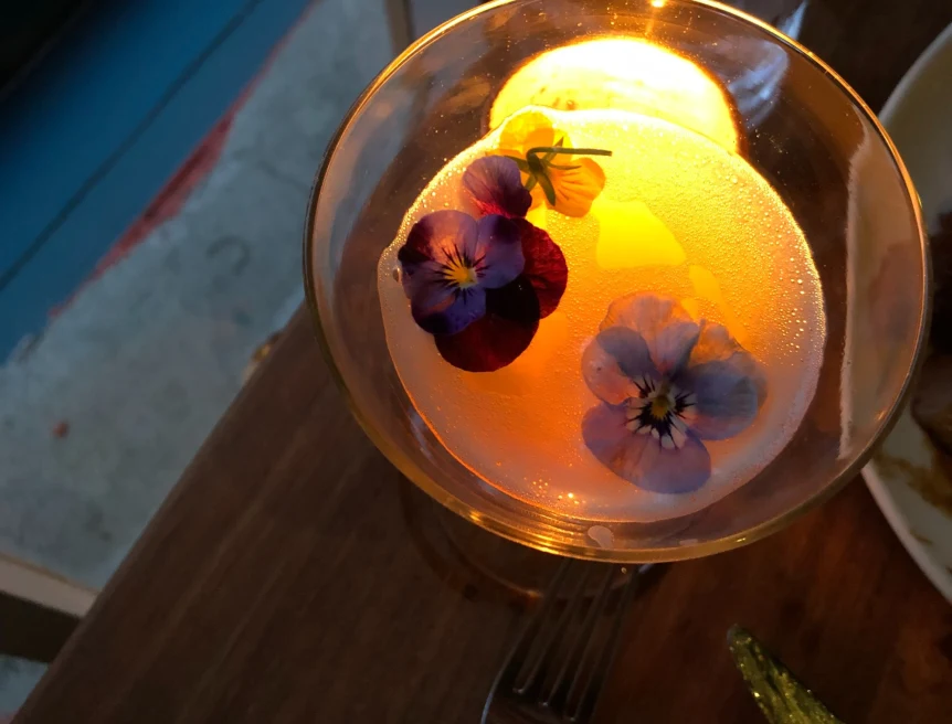 cocktail with flower petals and a candle