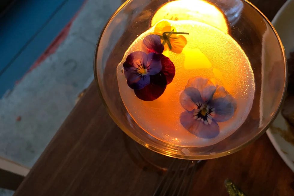 cocktail with flower petals and a candle