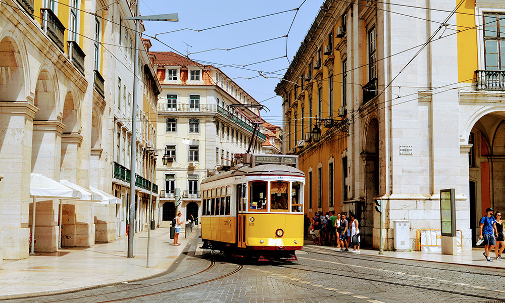 Lisbon city with yellow trolley and white stone buildings