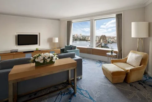 A suite in the Shangri-La Sydney, with plush couches and a view of the bridge.
