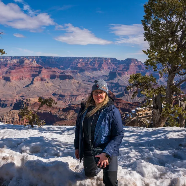 Travel Advisor Nicole Whelan in a blue jacket in front of the Grand Canyon.