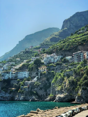 buildings on the side of a cliff near water during daytime