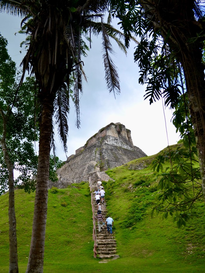 Green hill with stairs to rock formation during daytime
