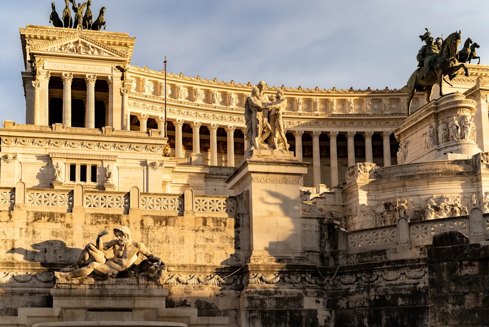 Roman architecture in Rome, Italy with cloudy skies in the background.