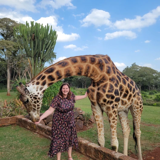 Fora travel agent Nadia Bess standing with giraffe
