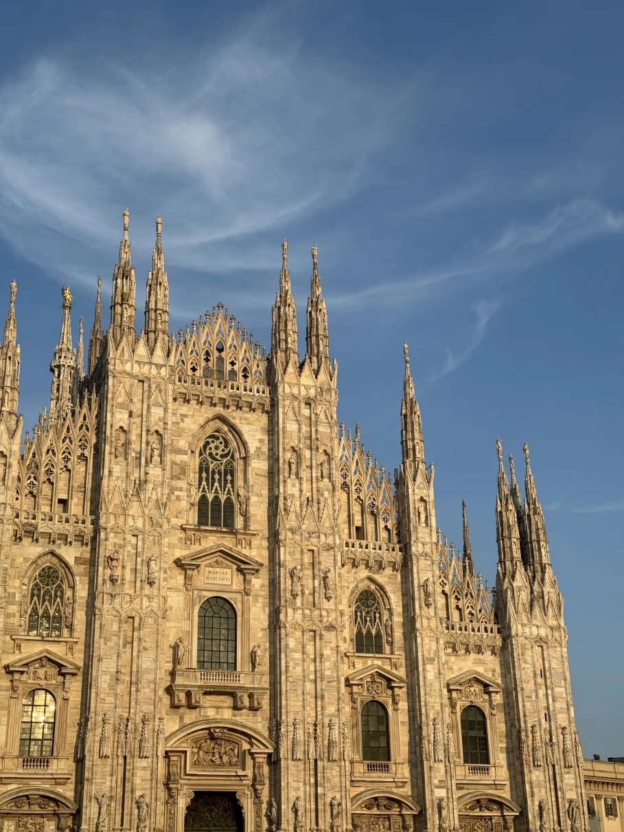 A white gothic church opening up to square at Duomo Cathedral Square in Milan, Italy.