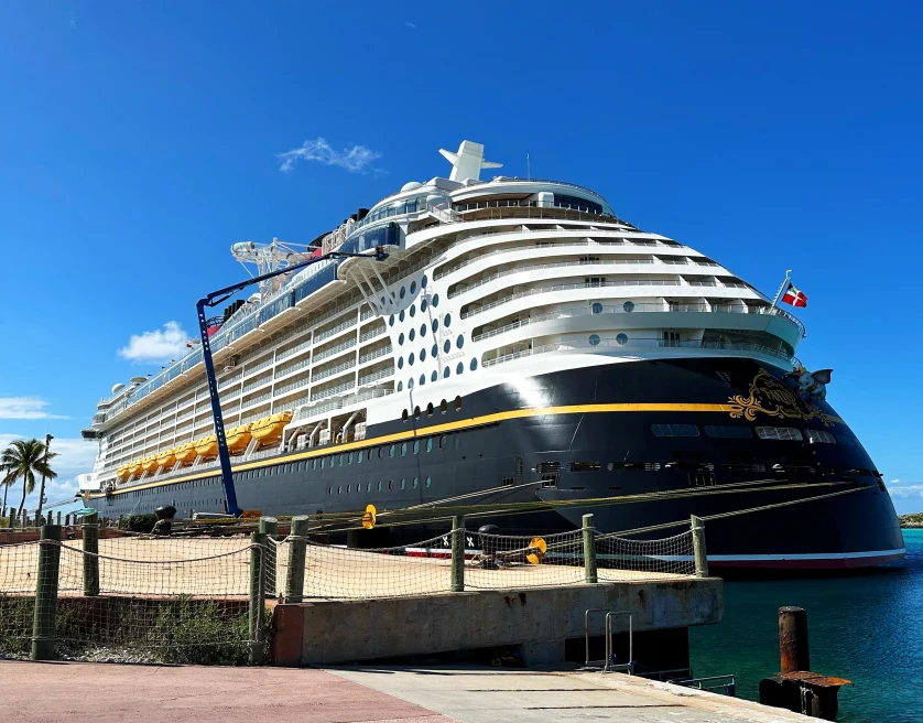 Disney cruise ship at port on a sunny day.
