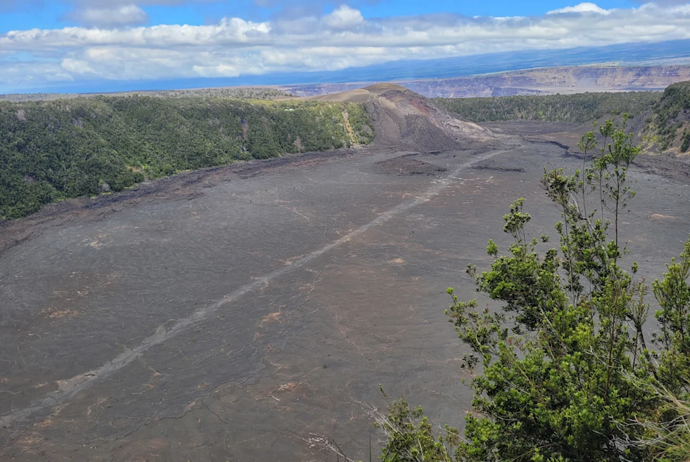 Gray rock formation with green foliage with blue skies during daytime