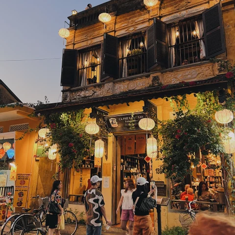 A frontal view of a charming restaurant in Hoi An in the evening with lanterns hanging outside