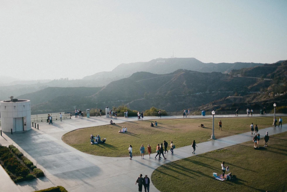 views of the hills of Los Angeles on a grassy plaza of a museum dotted with visitors