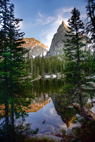 clear alpine lake surrounded by pine trees