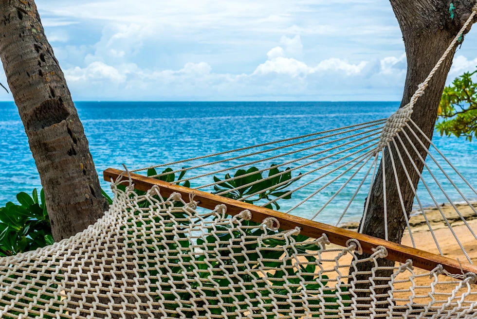 Blue sea and hammock on a beach.