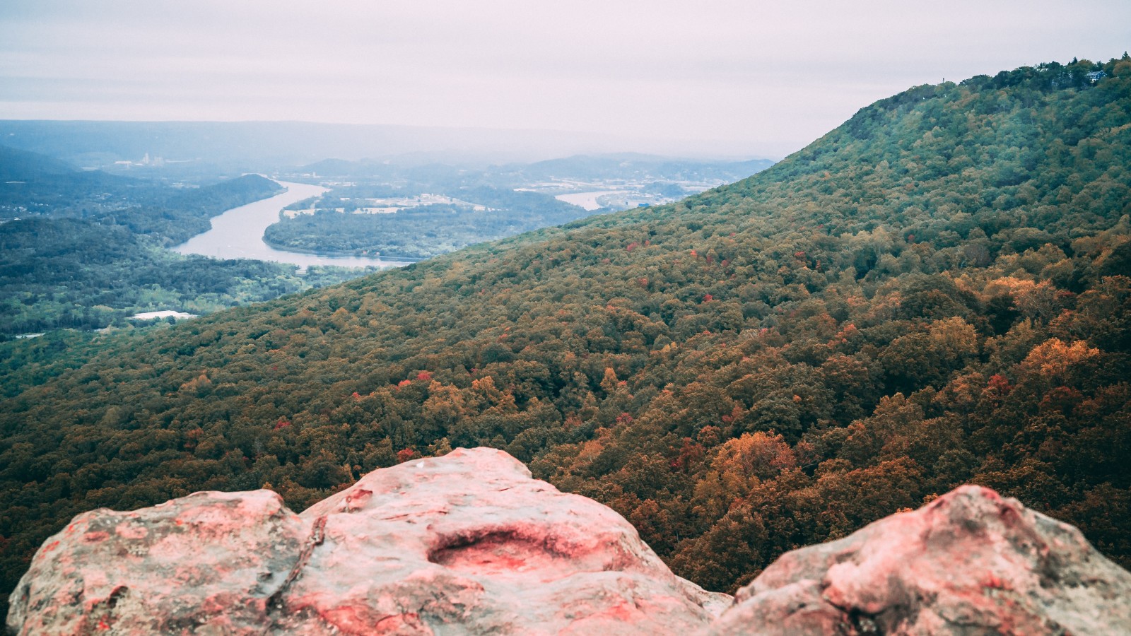 View from the top of a mountain in Chattanooga, Tennessee overlooking a river and hills dotted with green trees