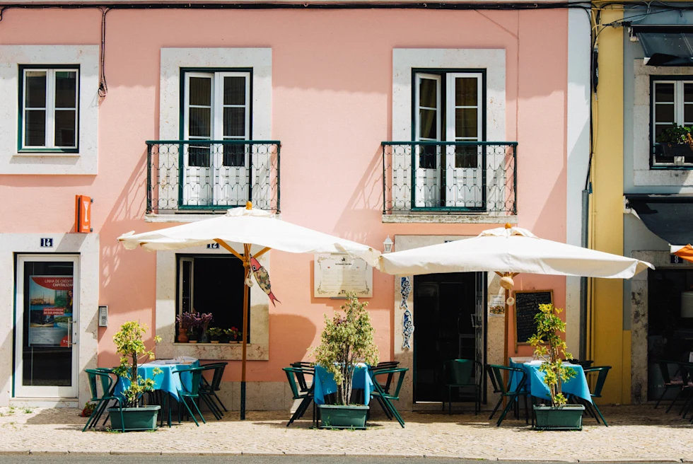 Chairs and tables arranged outside of a small cafe.