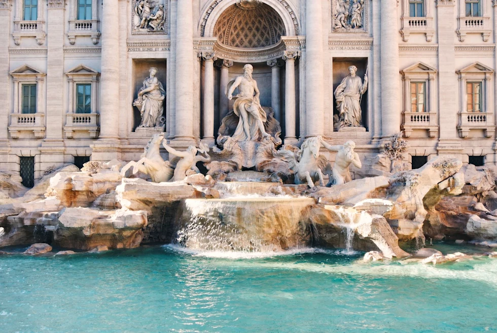 Water fountain with statues in front of a building.