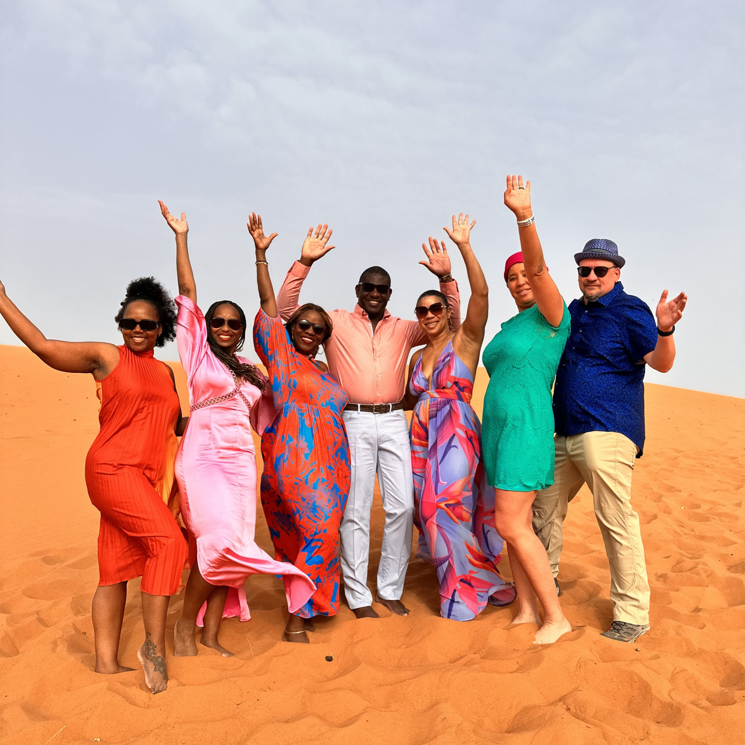 A group of people posing on sand
