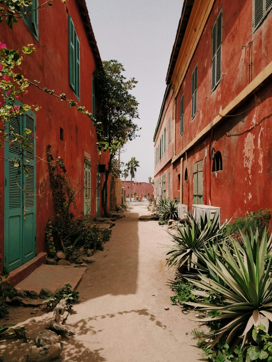 An alley between 2 red storey houses in Goree, Dakar, Senegal.