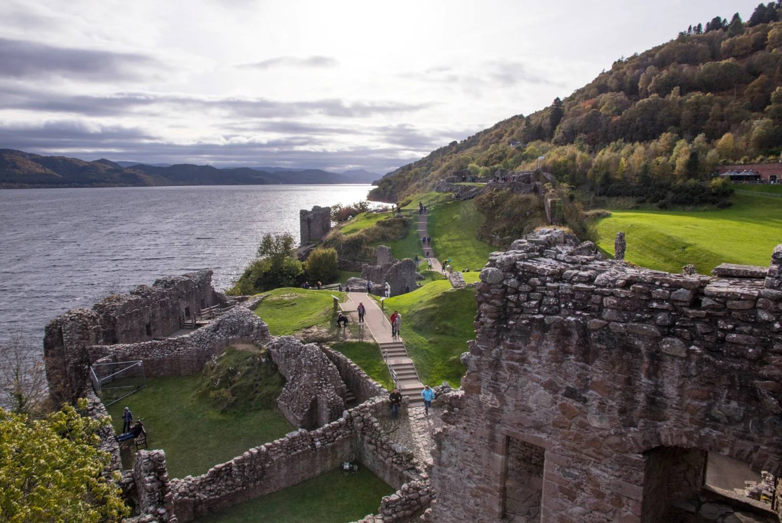 People exploring Urquhart Castle in Scotland, Inverness, UK