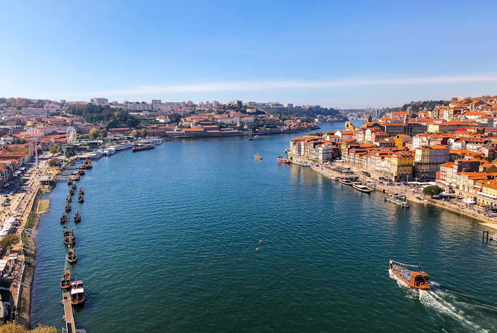 a river runs through a city with low white buildings and orange rooftops