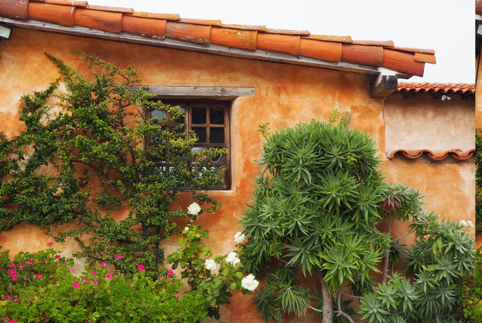 orange stucco building with flowers and plants