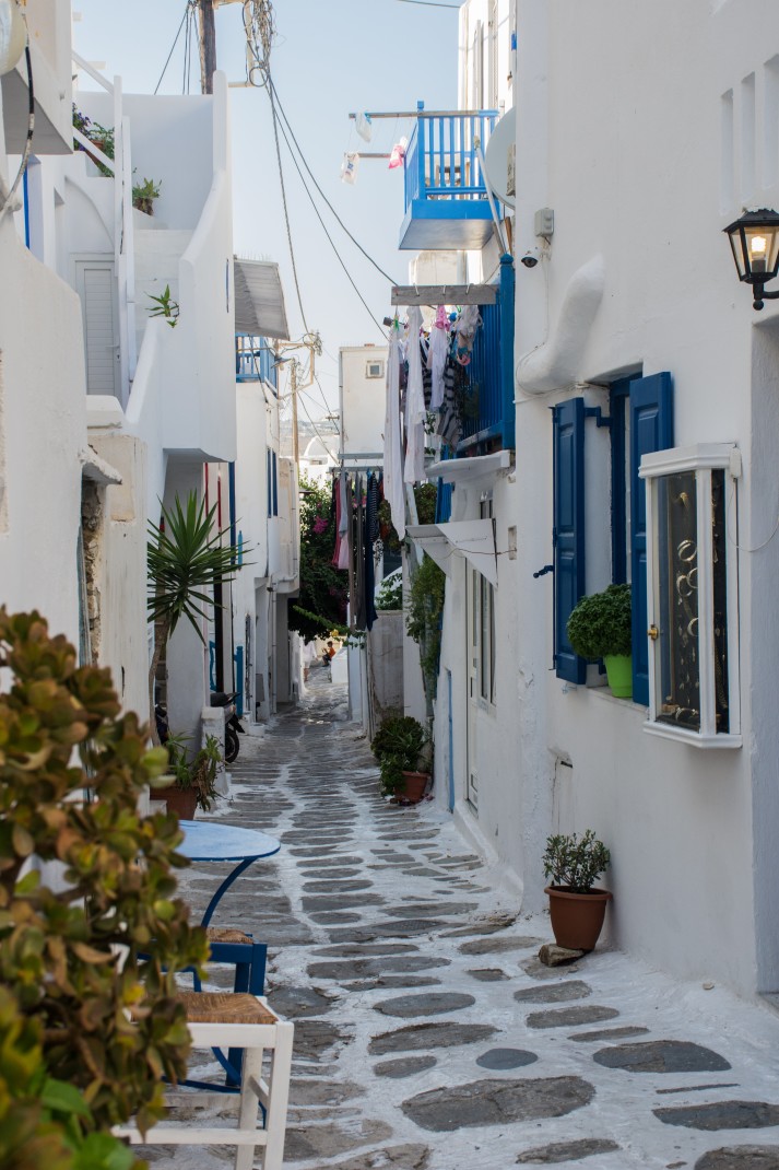 Street lined with white buildings and blue doors during daytime