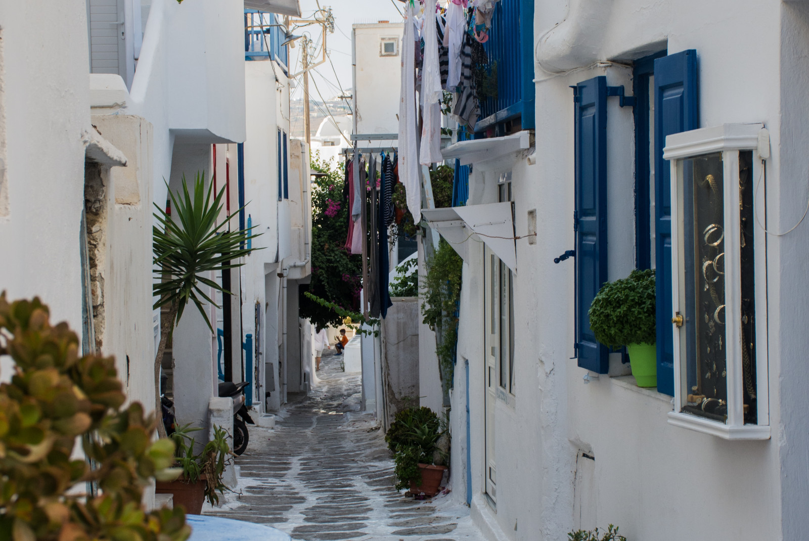 Street lined with white buildings and blue doors during daytime