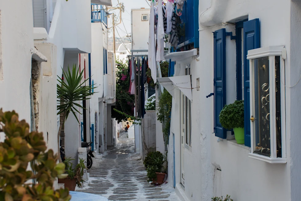 Street lined with white buildings and blue doors during daytime
