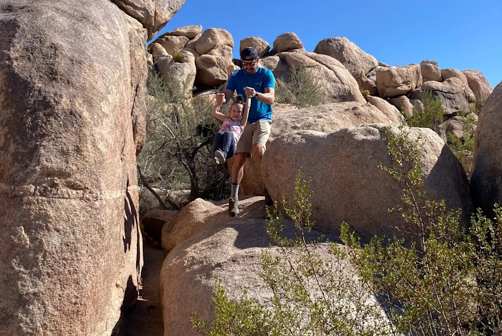 A dad and daughter on a rock in Joshua Tree.