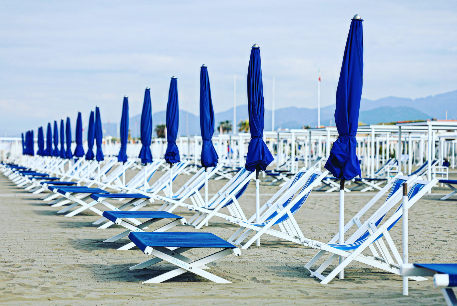 blue beach chairs on the beach with cloudy skies