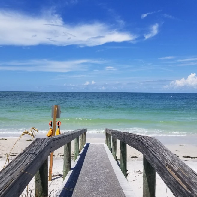 a boardwalk leads to the sandy ocean