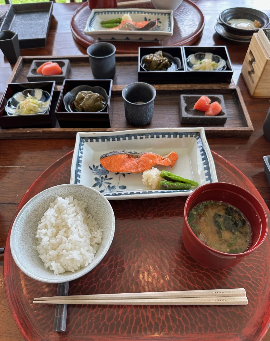 Plates of Japanese breakfast food like rice and miso soup on a table at Zaborin.