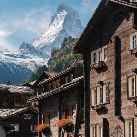 wood houses with mountains in the background during daytime