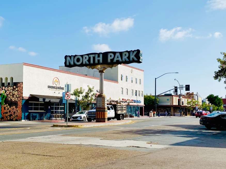 a neighborhood in sunny California with a big sign that reads, "North Park"